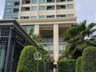 Modern high-rise building with lush greenery and elegant entrance