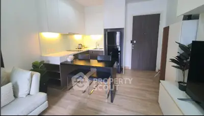 Modern open-layout kitchen and living area with sleek design and cozy ambiance.