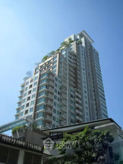 Stunning high-rise building with modern architecture and lush greenery, perfect for urban living.