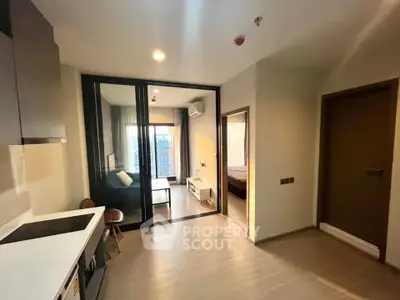Modern apartment interior with open kitchen and cozy living area, featuring sleek design and natural light.