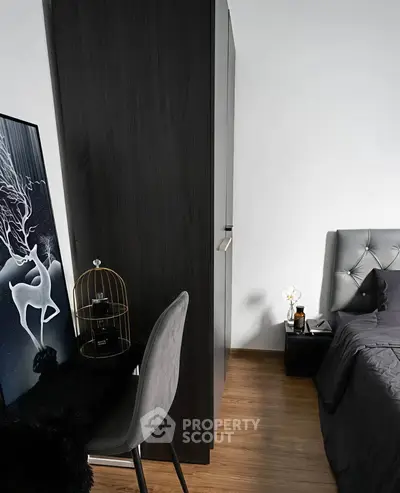 Modern bedroom with stylish decor and sleek furniture, featuring a cozy bed and elegant artwork.