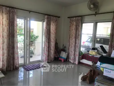 Spacious living room with large windows and garden view, perfect for family gatherings.