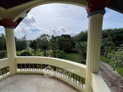 Spacious balcony with lush garden view in a serene residential area.
