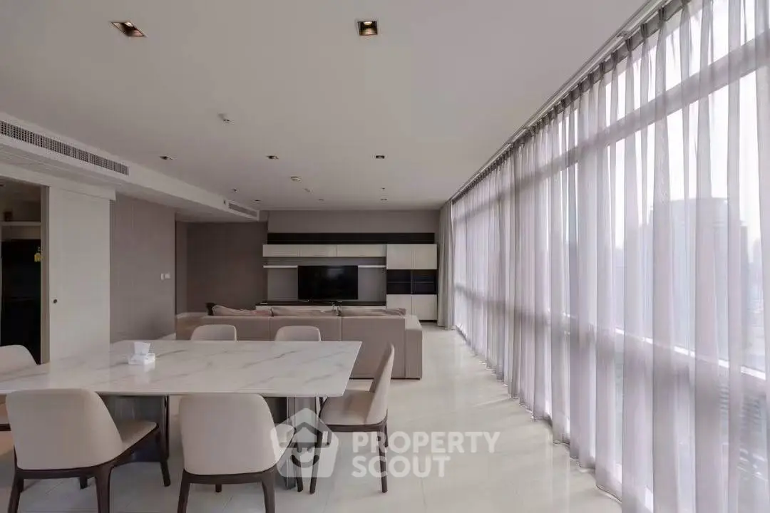 Spacious modern living room with large windows and elegant dining area