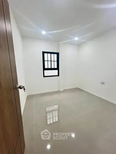 Spacious empty room with glossy tiled floor and bright lighting, ideal for customization.