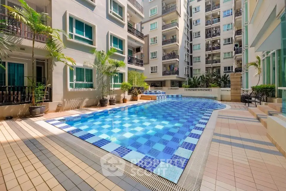 Luxurious apartment complex with a stunning outdoor pool and modern architecture.