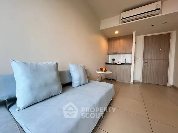 Modern living room with sleek furniture and compact kitchen area