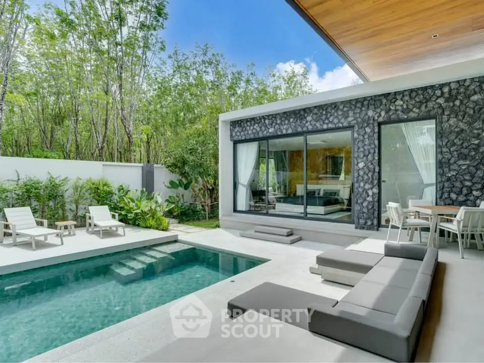 Luxurious modern villa with private pool and stylish outdoor seating area, surrounded by lush greenery.