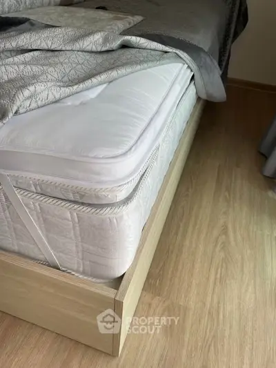 Cozy bedroom with modern wooden bed frame and plush mattress