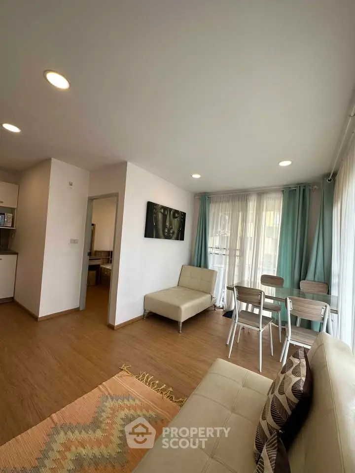 Modern living room with stylish decor and natural light, featuring a cozy seating area and dining space.