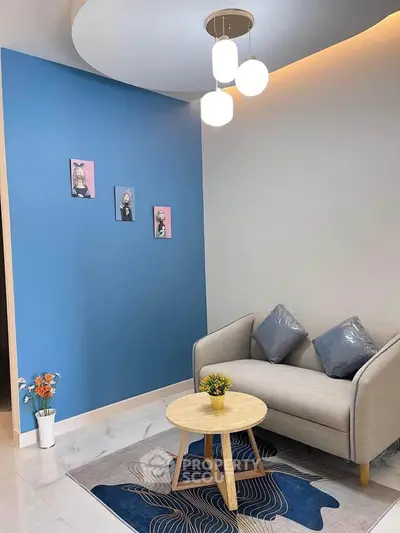 Stylish modern living room with blue accent wall and cozy seating area.
