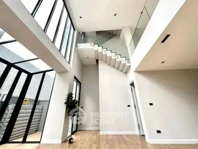 Stunning modern interior with high ceilings and large windows in a luxury home.