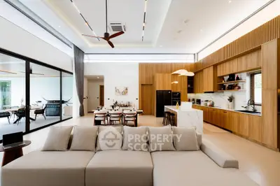 Luxurious open-plan living room with modern kitchen and elegant dining area, featuring high ceilings and stylish decor.
