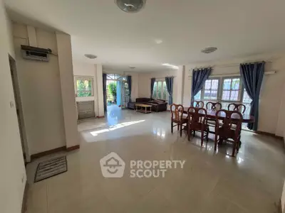 Spacious living room with elegant dining area and large windows for natural light.