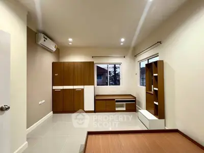 Spacious bedroom with modern wooden furniture and large windows for natural light.