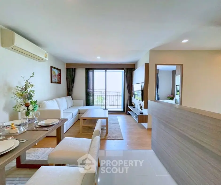 Spacious modern living room with open layout and balcony view in a stylish apartment.
