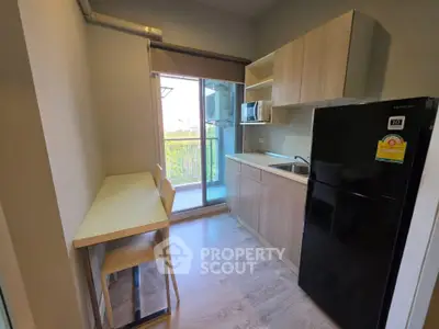 Modern compact kitchen with balcony view, featuring sleek cabinetry and appliances.