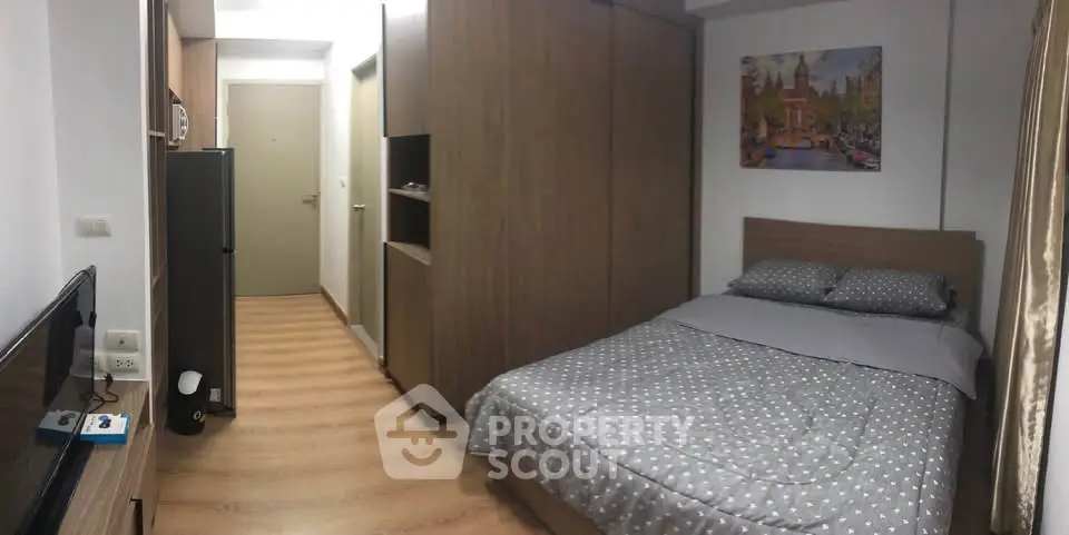 Cozy bedroom with modern decor and ample storage in a stylish apartment.