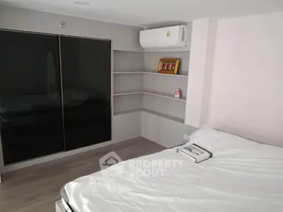 Modern bedroom with sleek design, featuring built-in wardrobe and air conditioning for ultimate comfort.