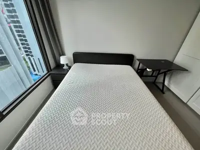 Modern bedroom with large window and minimalist furniture in urban apartment