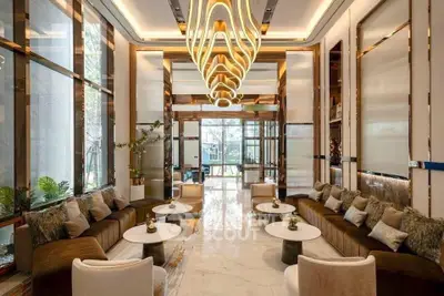 Luxurious modern living room with elegant chandelier and plush seating in a high-end property.