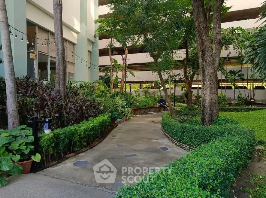 Lush garden courtyard in modern residential building with vibrant greenery.