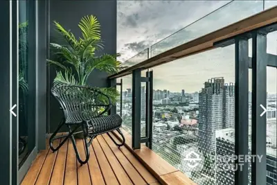 Stunning cityscape view from modern balcony with stylish seating and lush greenery.