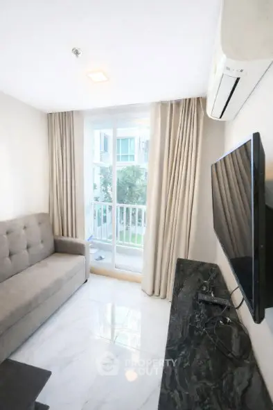 Modern living room with sleek design, featuring a plush sofa, wall-mounted TV, and large window with balcony view.