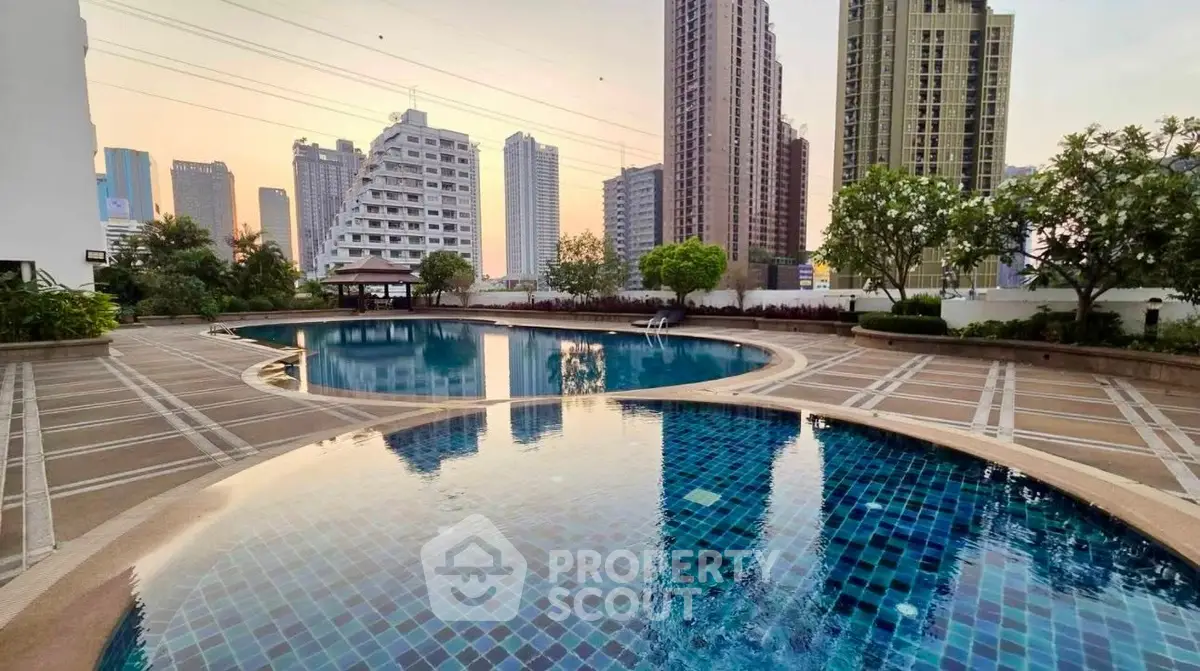 Luxurious urban swimming pool with stunning cityscape views, perfect for relaxation and leisure in a modern residential complex.