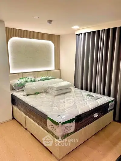 Modern bedroom with stylish lighting and new mattress in a cozy apartment.