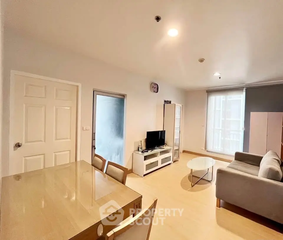 Spacious living room with modern furniture and natural light, perfect for relaxation and entertainment.