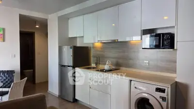 Modern kitchen with sleek appliances and washing machine in stylish apartment