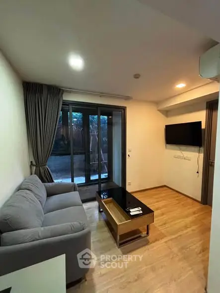 Modern living room with sleek design and cozy ambiance, featuring a comfortable sofa and wall-mounted TV.