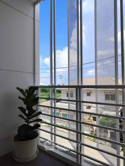 Charming balcony view with lush greenery and modern railing design.