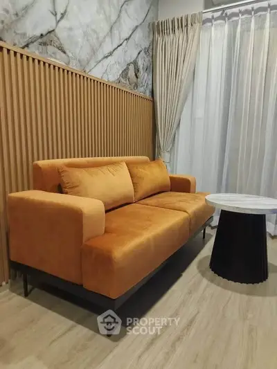 Stylish living room with modern orange sofa and elegant marble accent wall
