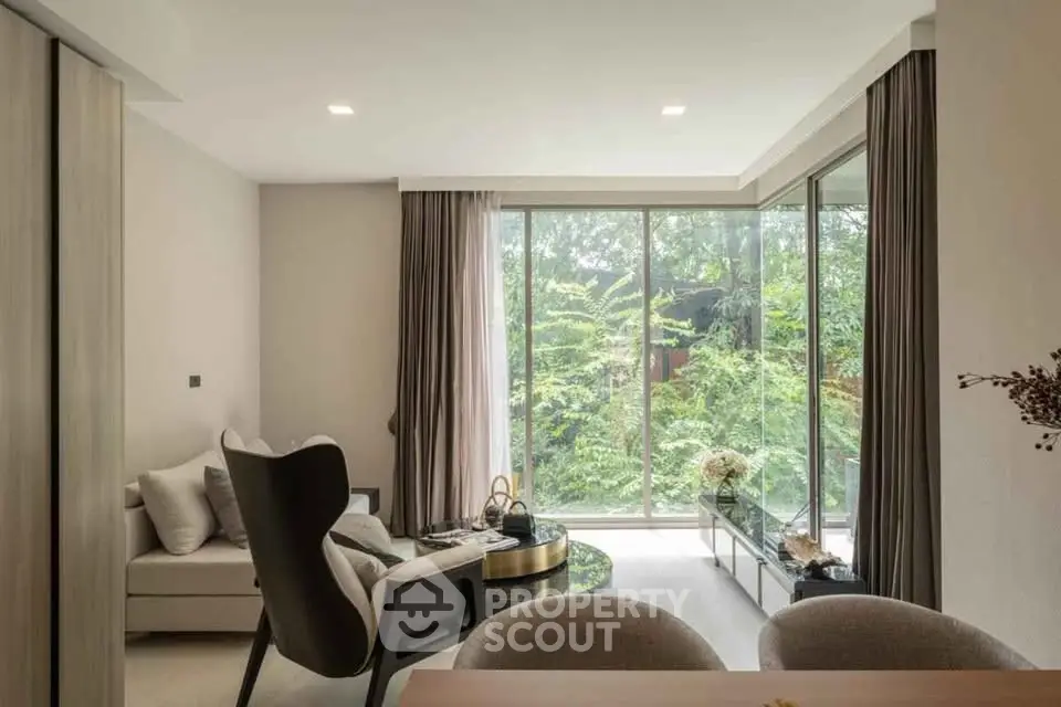 Elegant living room with large windows and lush garden view, featuring modern furniture and cozy ambiance.