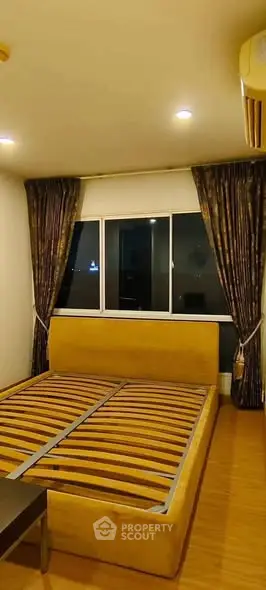 Spacious bedroom with large window and elegant curtains in modern apartment