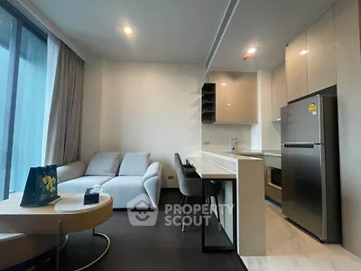 Modern open-layout living room with sleek kitchen and cozy seating area.