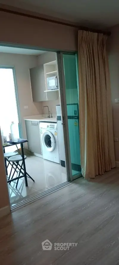 Cozy apartment with washing machine and sliding glass door to balcony