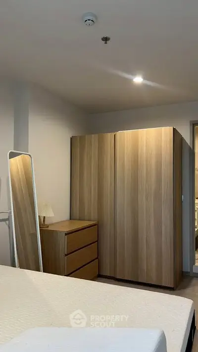 Modern bedroom with sleek wooden wardrobe and minimalist decor