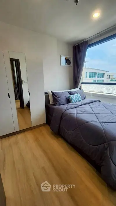 Modern bedroom with large window and stylish decor in a contemporary home.