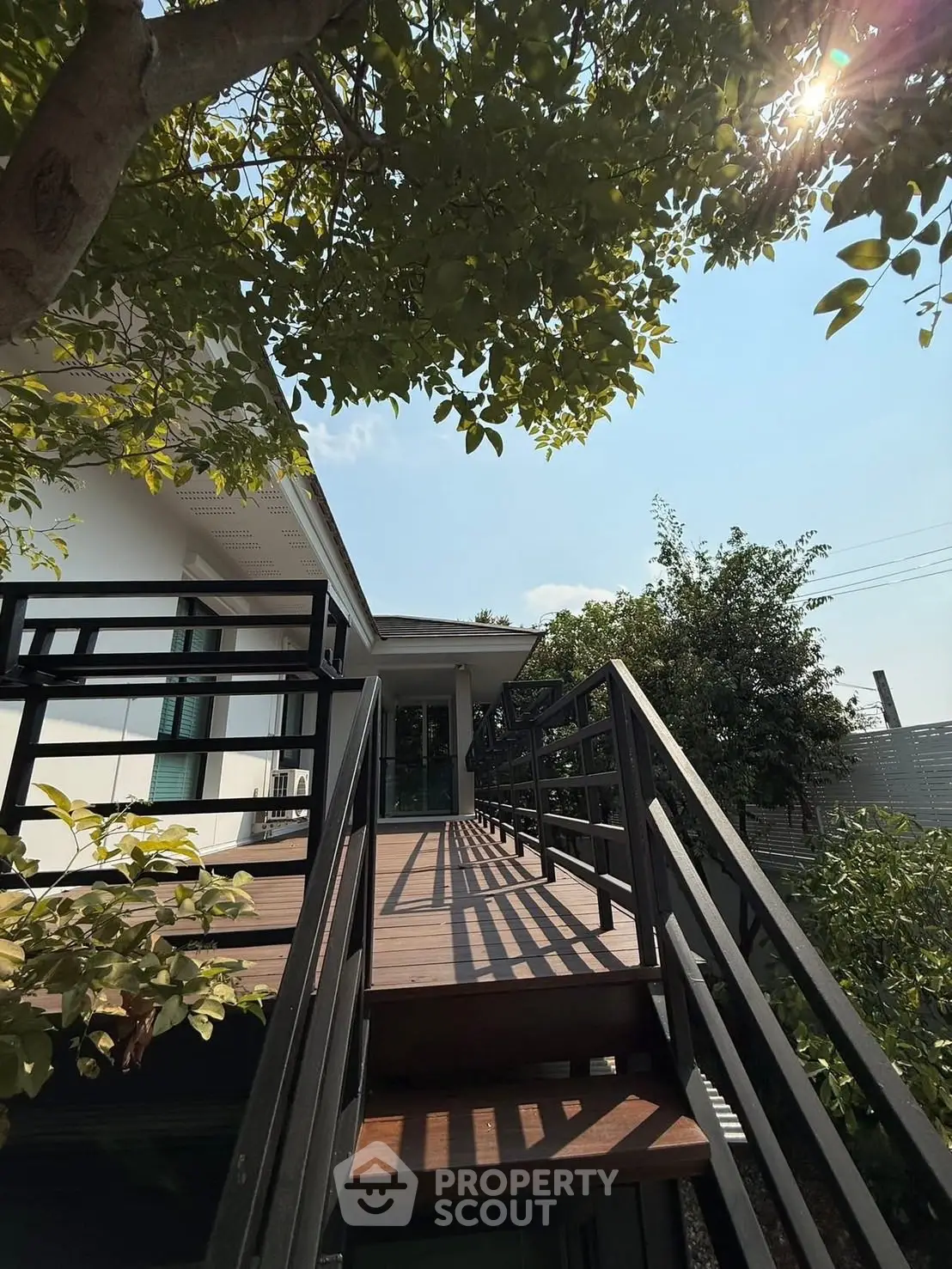 Charming modern home with inviting wooden deck and lush greenery, perfect for relaxation and outdoor enjoyment.