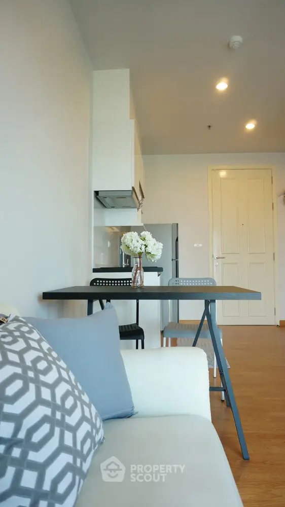 Modern living room with stylish decor and open kitchen layout in a cozy apartment.