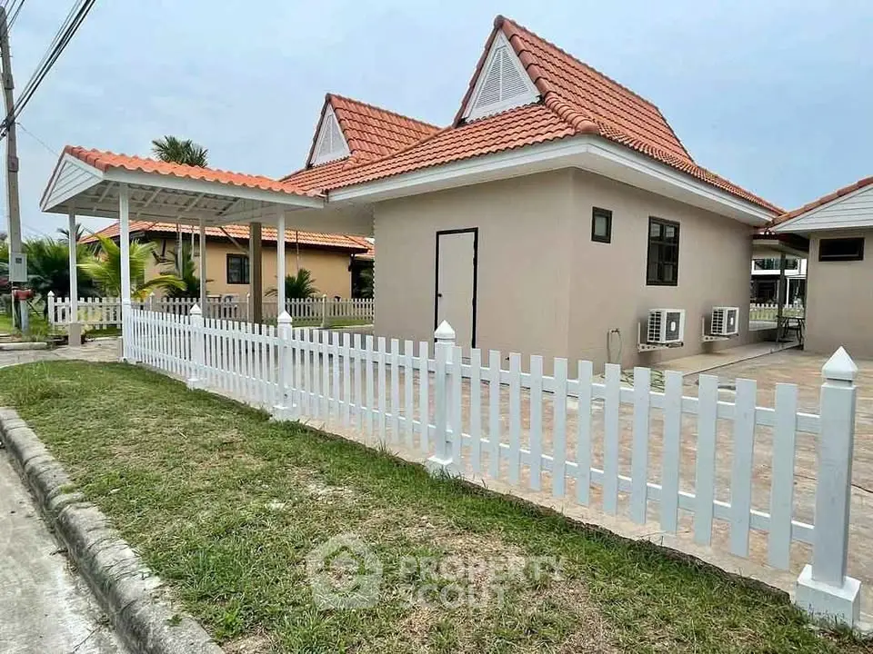 Charming suburban home with red-tiled roof and white picket fence