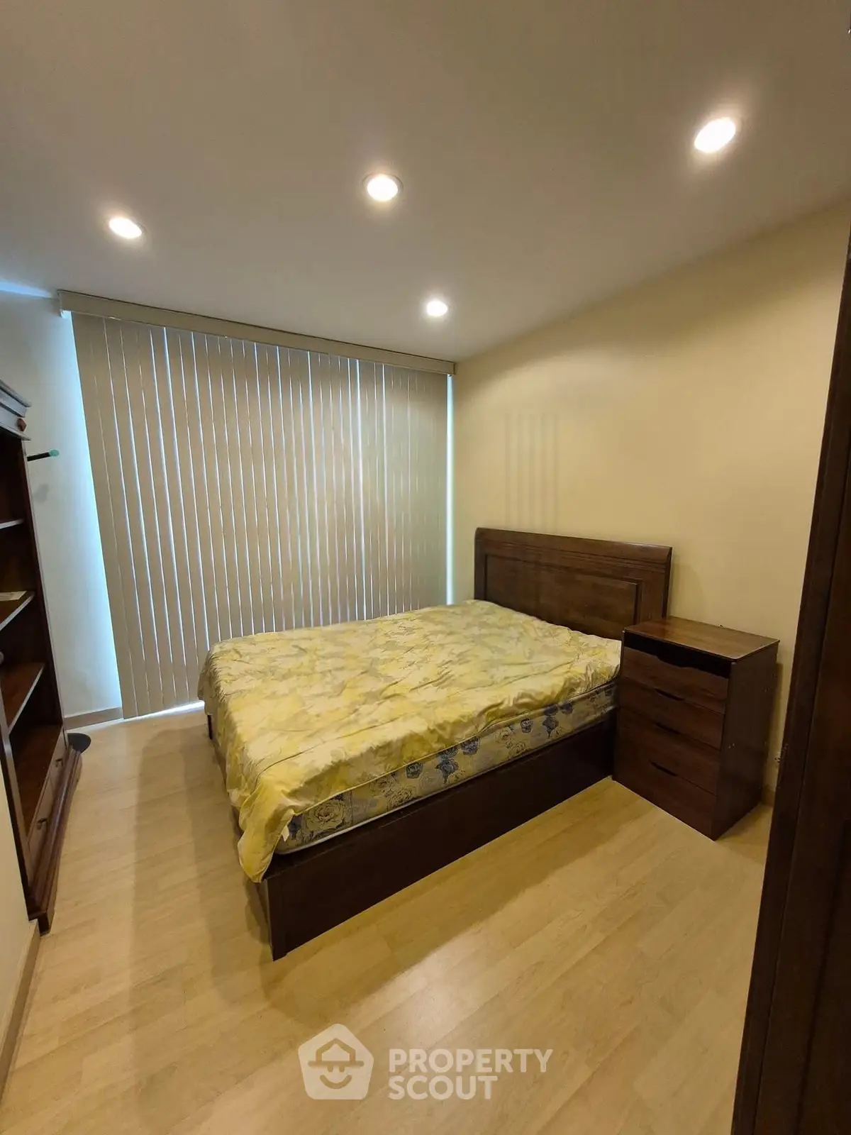 Cozy bedroom with wooden furniture and large window blinds