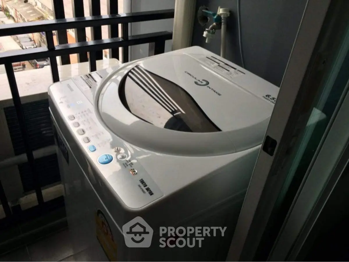 Modern washing machine on apartment balcony with city view