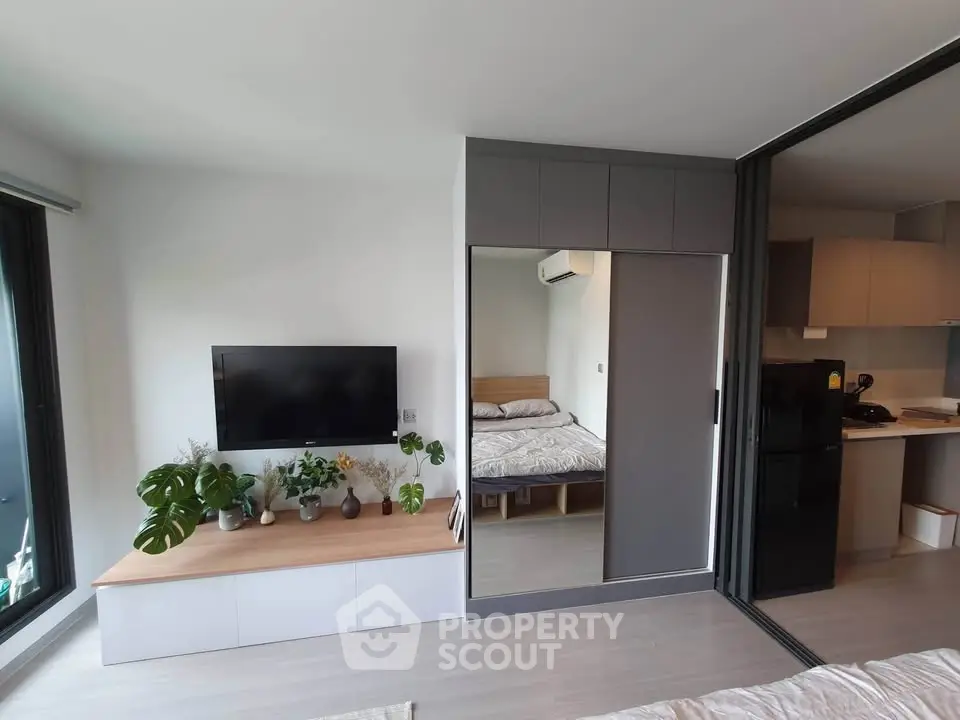 Modern apartment interior with open living space, sleek kitchen, and cozy bedroom.