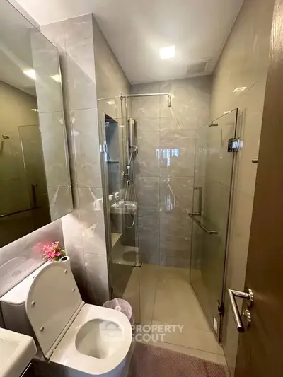Modern bathroom with glass shower enclosure and sleek fixtures