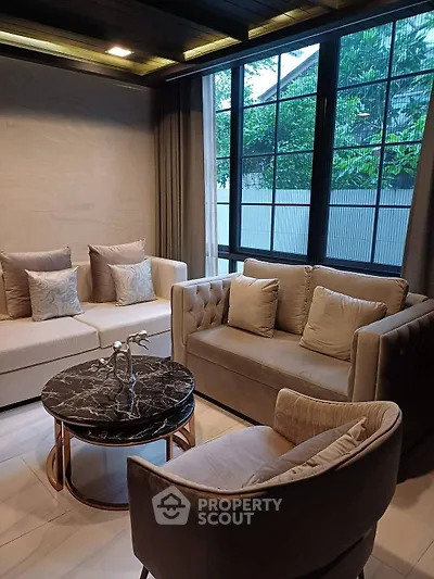 Elegant living room with plush seating and large windows offering natural light.