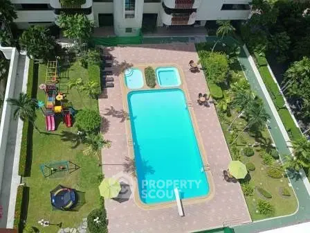 Luxurious residential complex with a pristine swimming pool and lush garden view.
